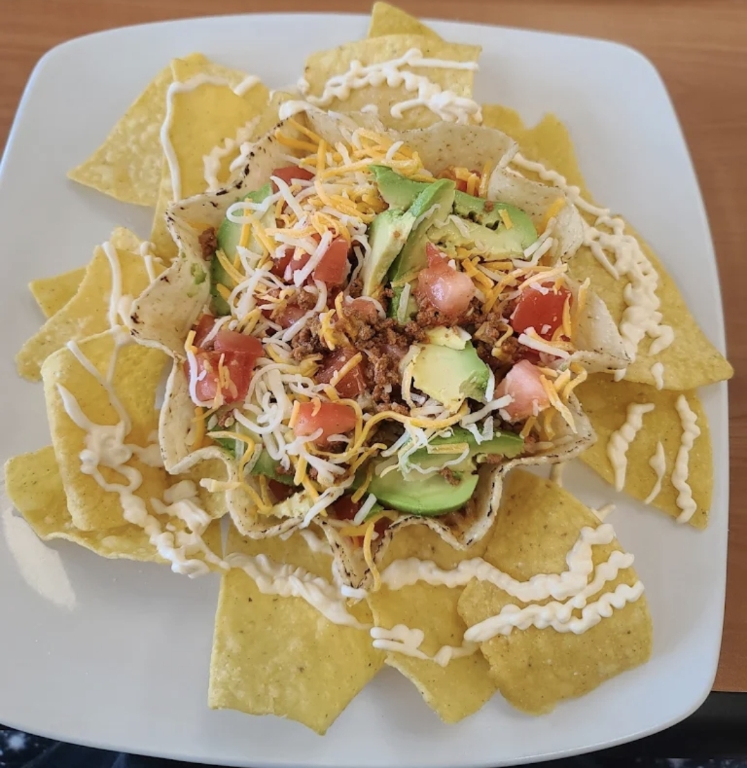 Nacho Supreme bowl with avocado, cheese, pico and crema drizzle
