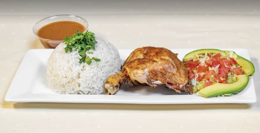 Pollo frito platter with rice, beans and avocado salad