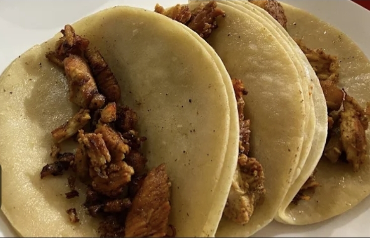 Three al pastor tacos on warm corn tortillas